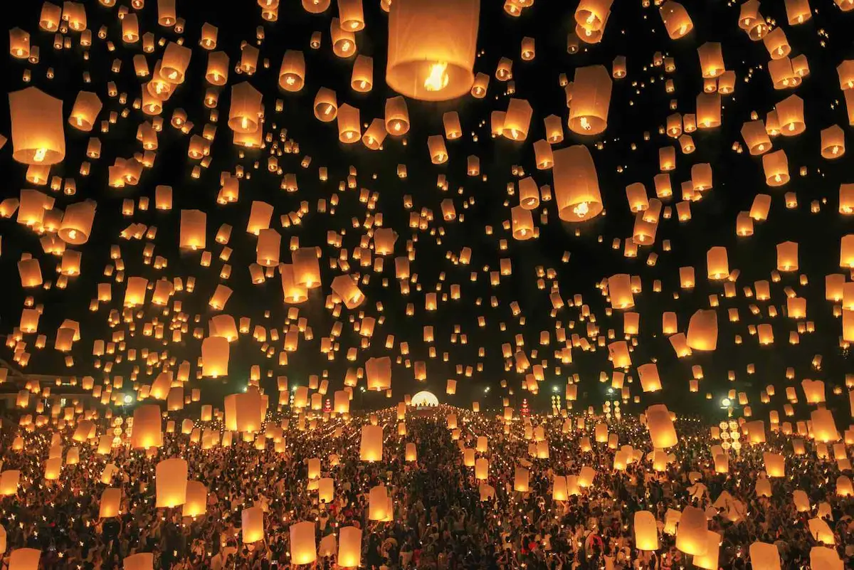 Lanterns rising into the night sky during Yi Peng festival in Chiang Mai