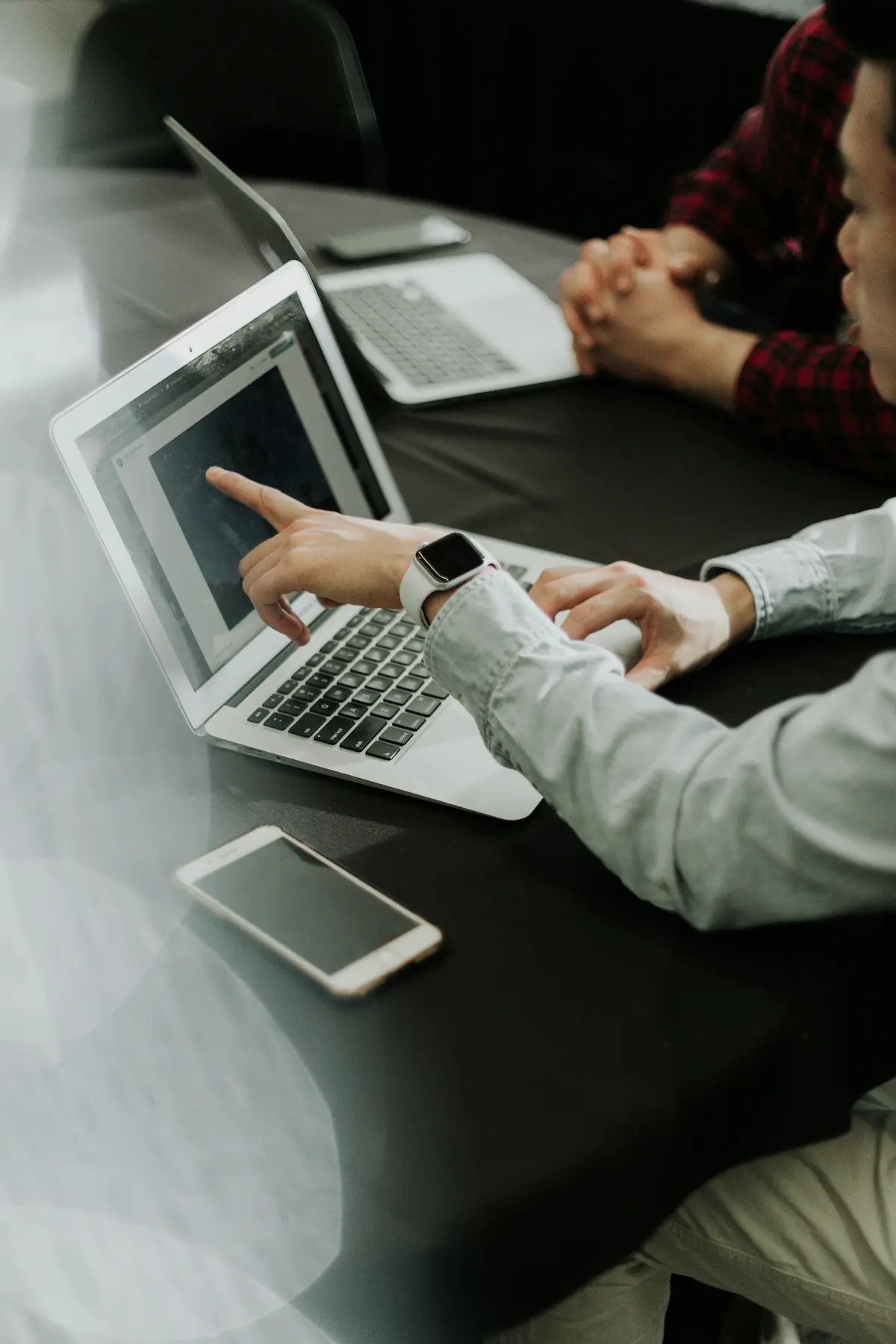 Two people consulting together over laptops